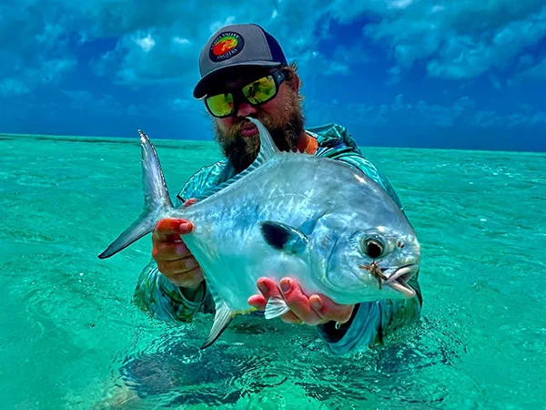 A man holding a fish in the ocean.