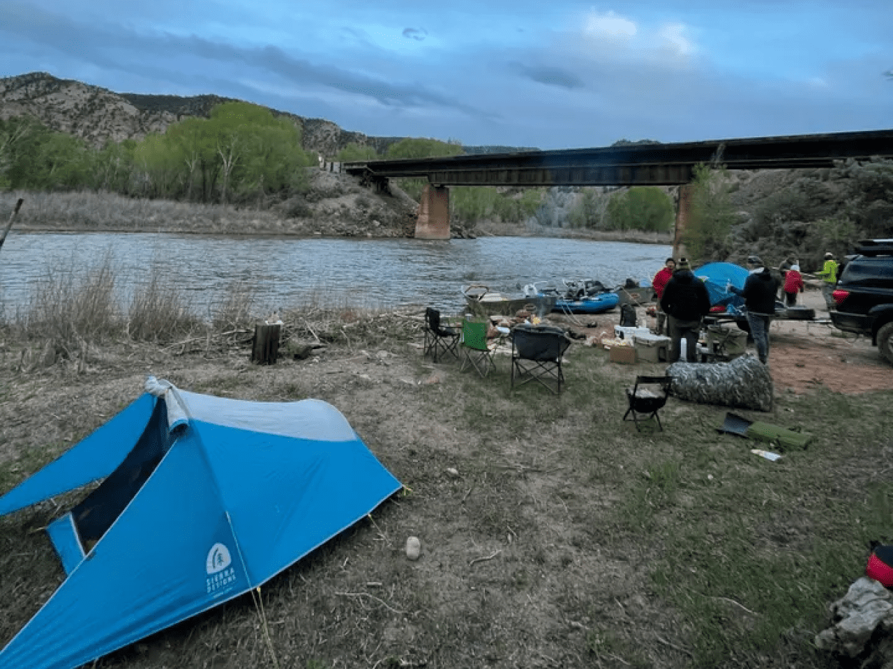 A blue tent is pitched near the water.