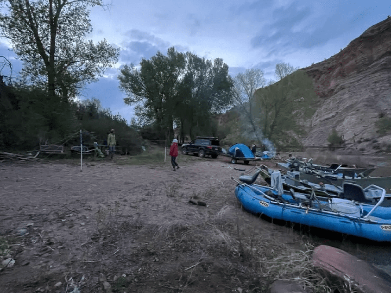 A man standing next to an inflatable boat.