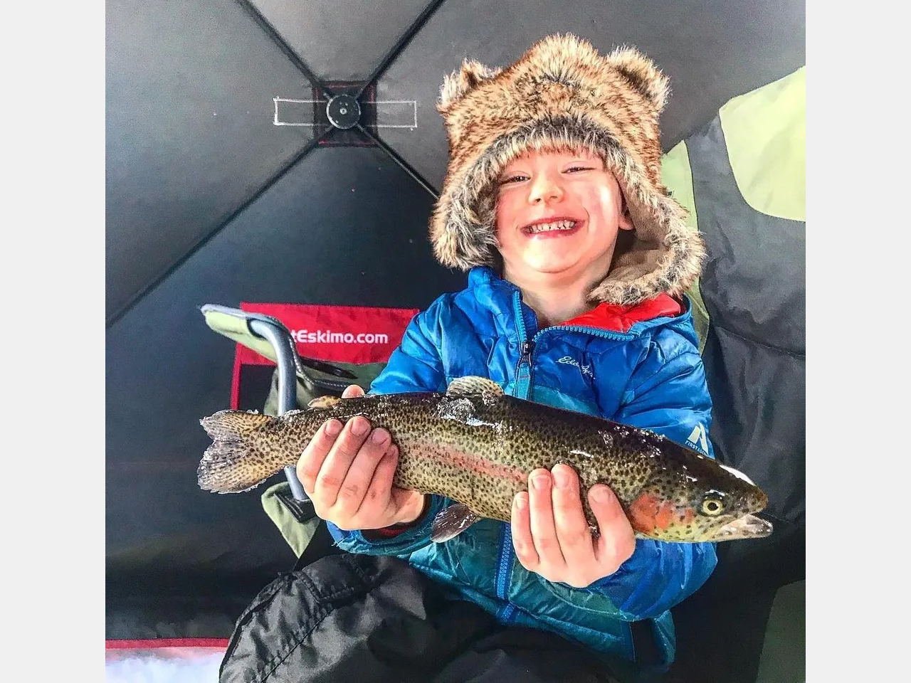 A young boy holding a fish in his hands.