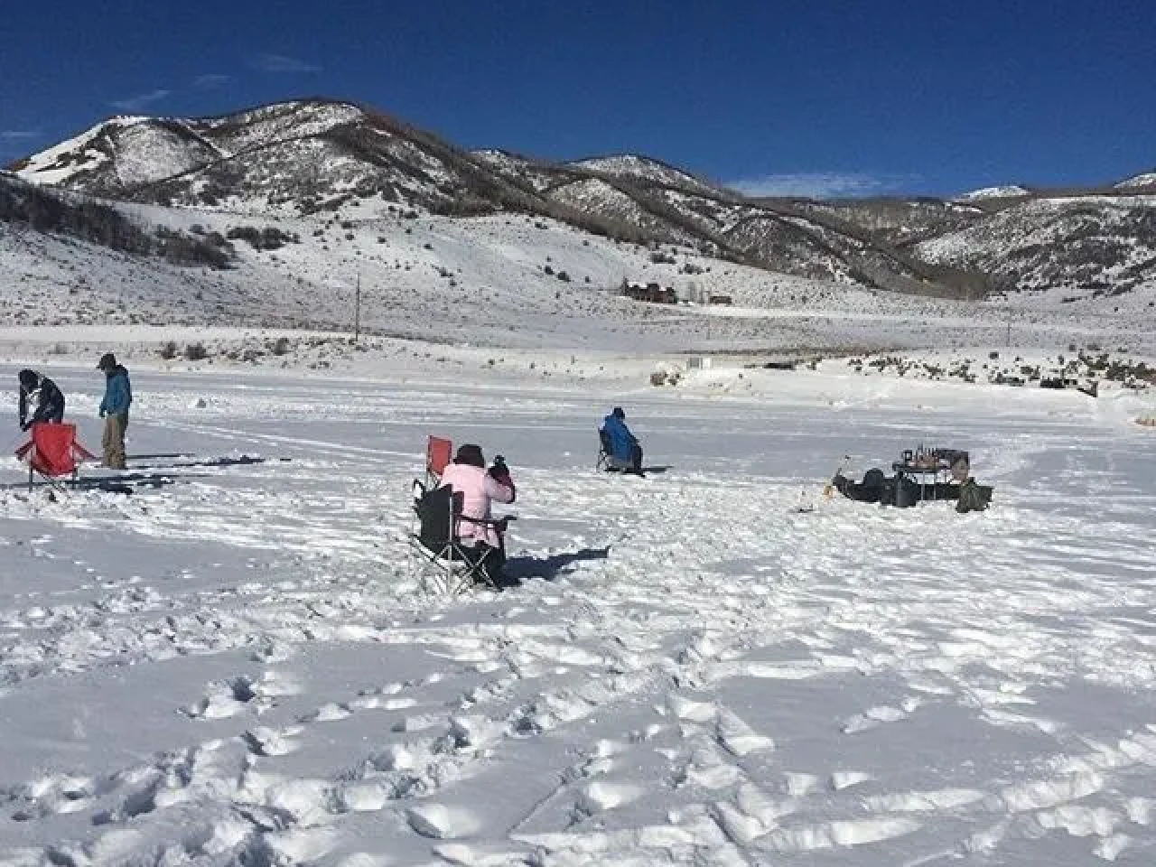 A group of people riding on the snow covered ground.