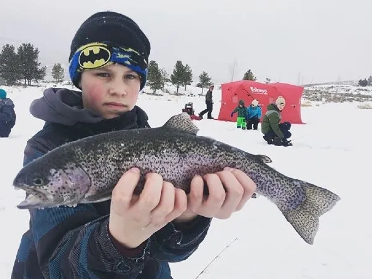 A boy holding a fish in his hands.