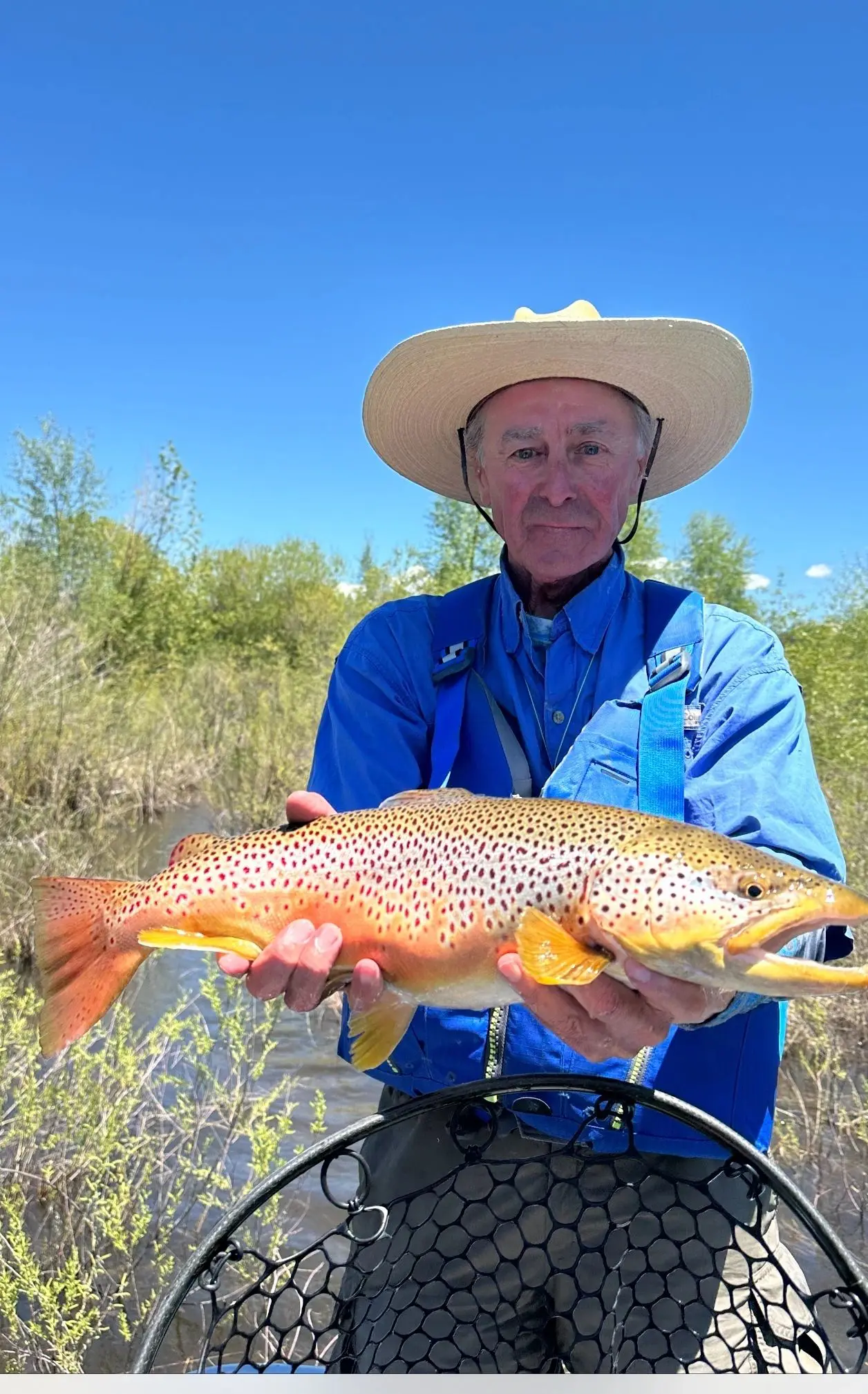 A man holding a brown fish in his hands.