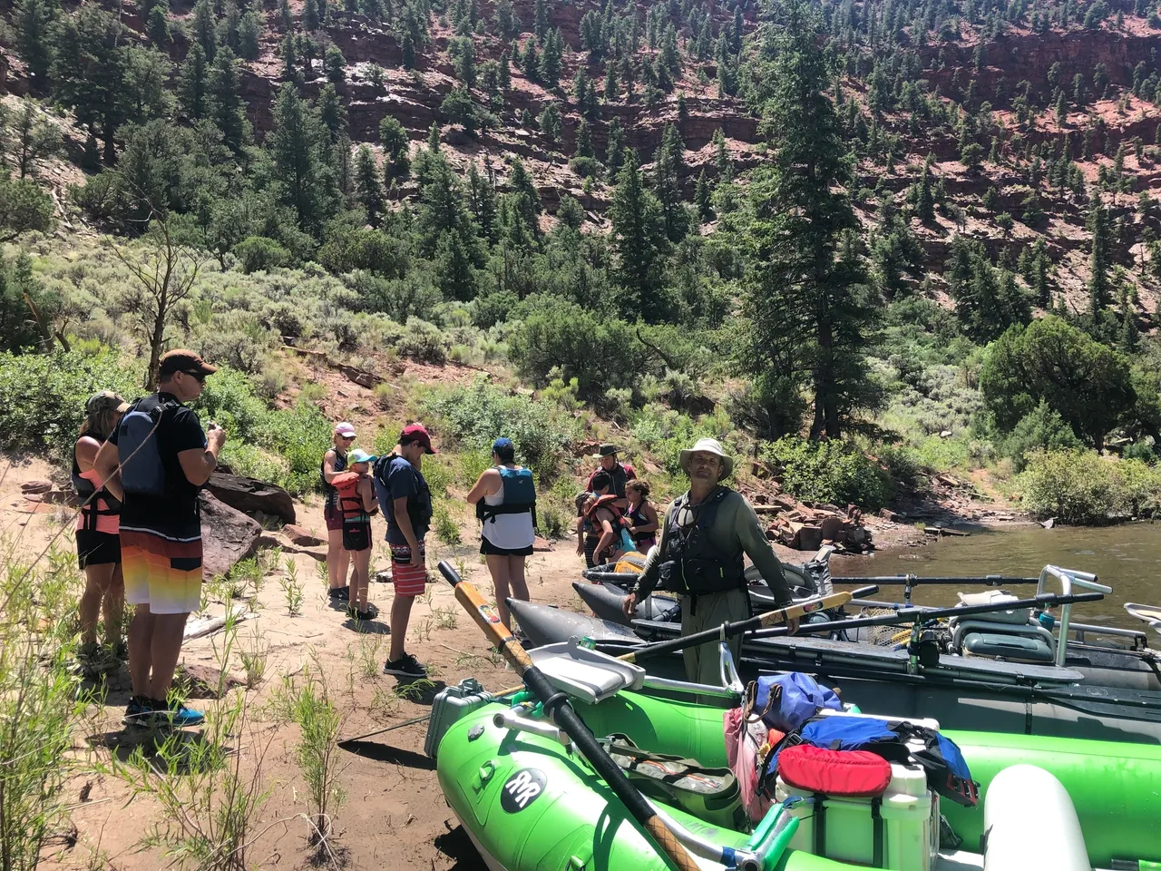 A group of people standing next to a raft.