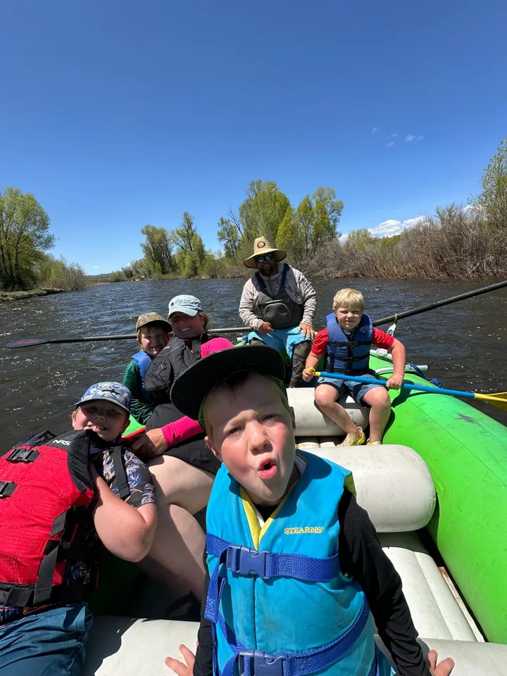 A group of people on a raft in the water.