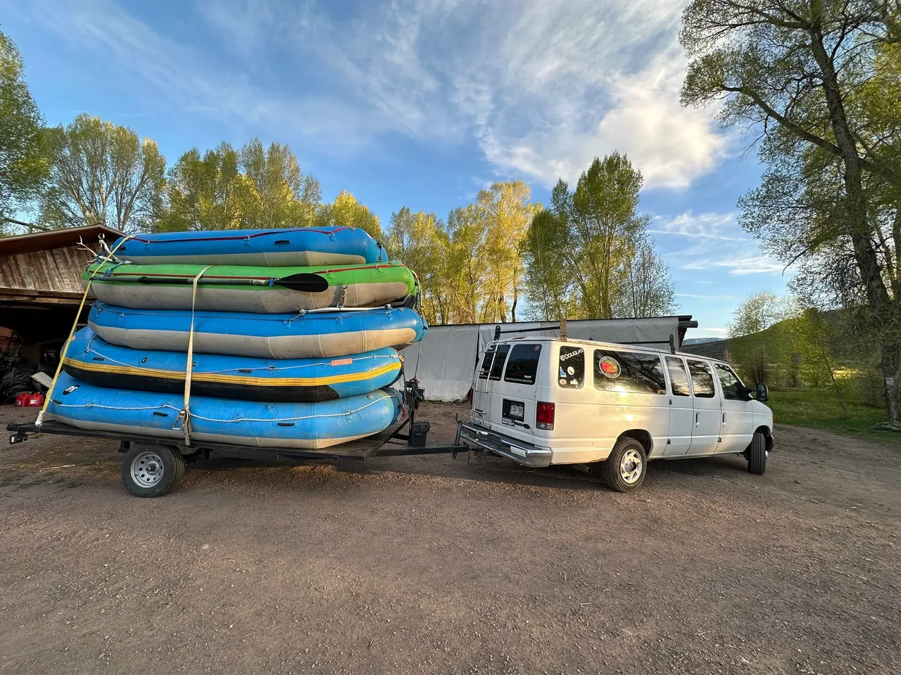 A van pulling a trailer full of boats.