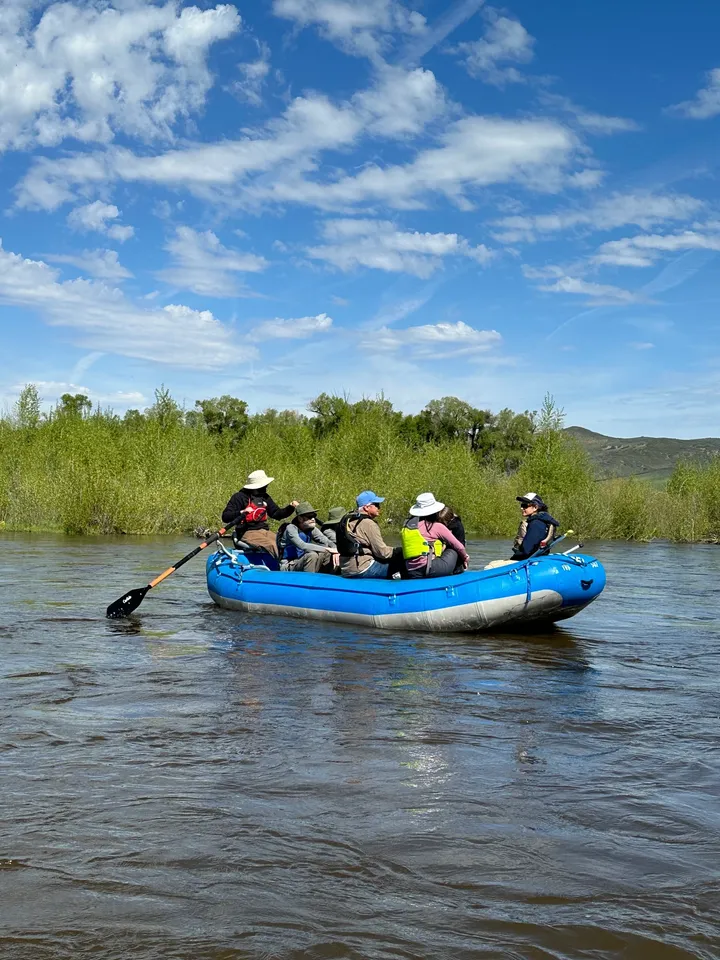 A group of people in a raft on the water.