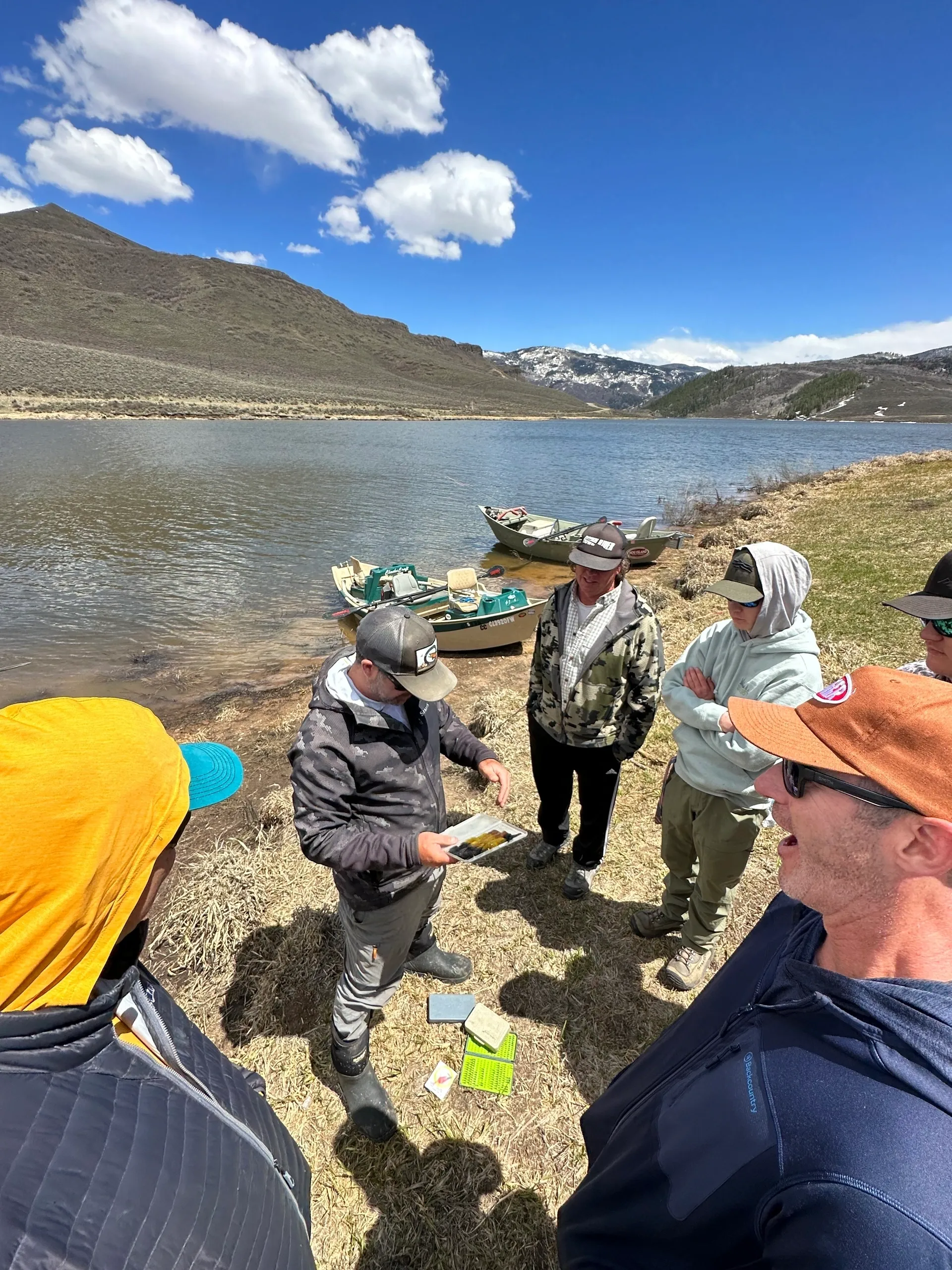 A group of people standing around a body of water.