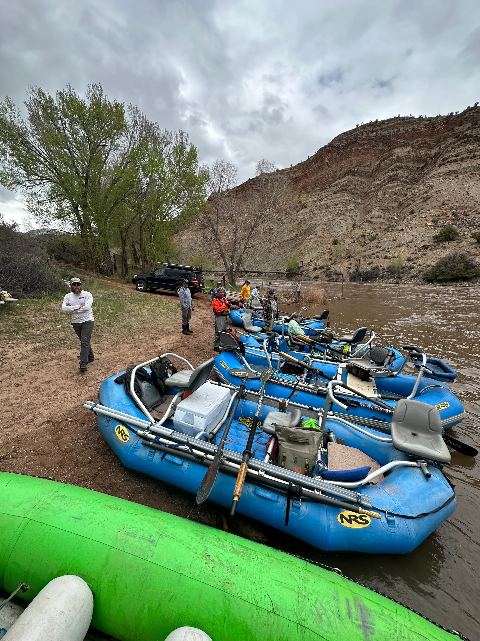 A group of people standing next to blue boats.