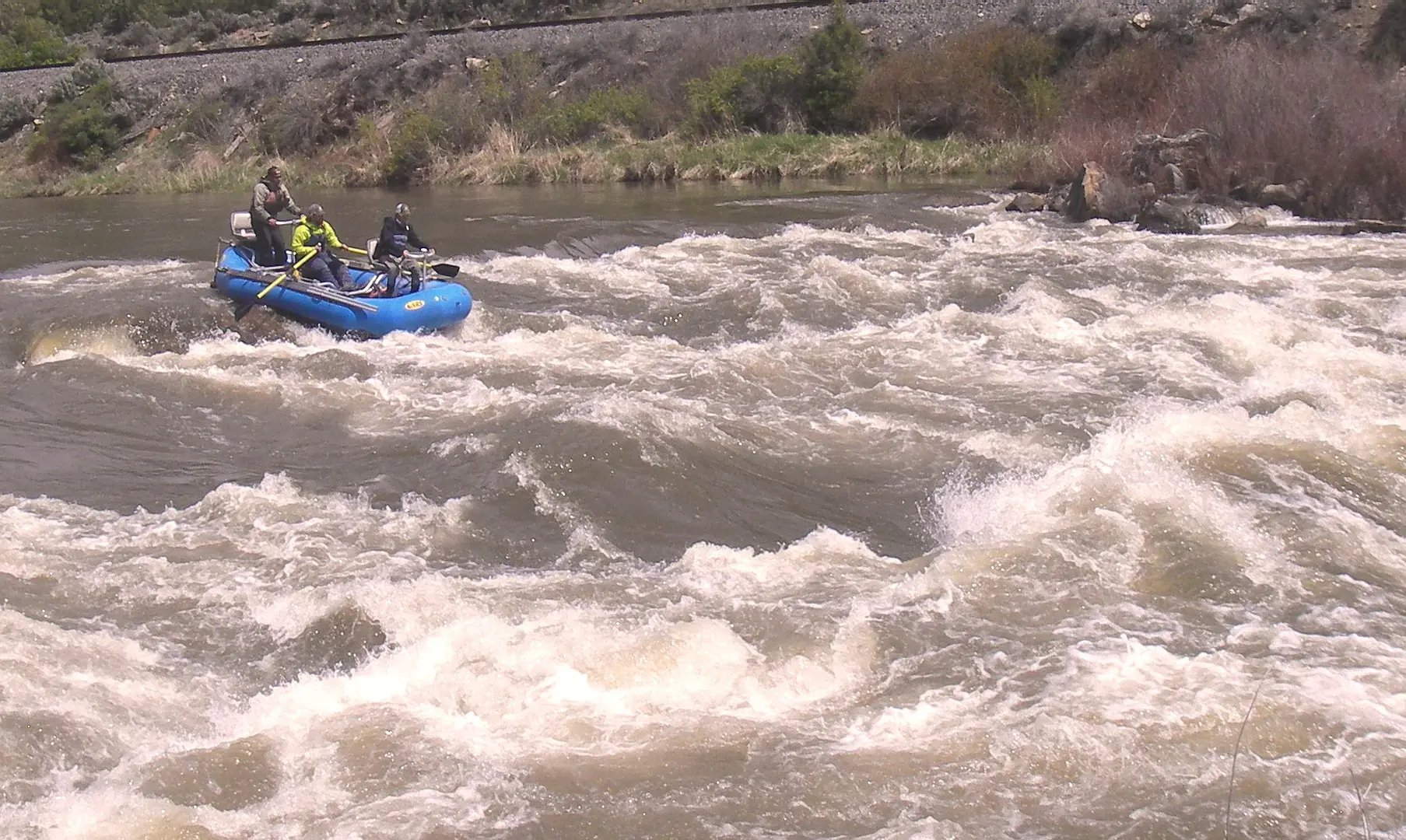 A man is in the water on a raft.