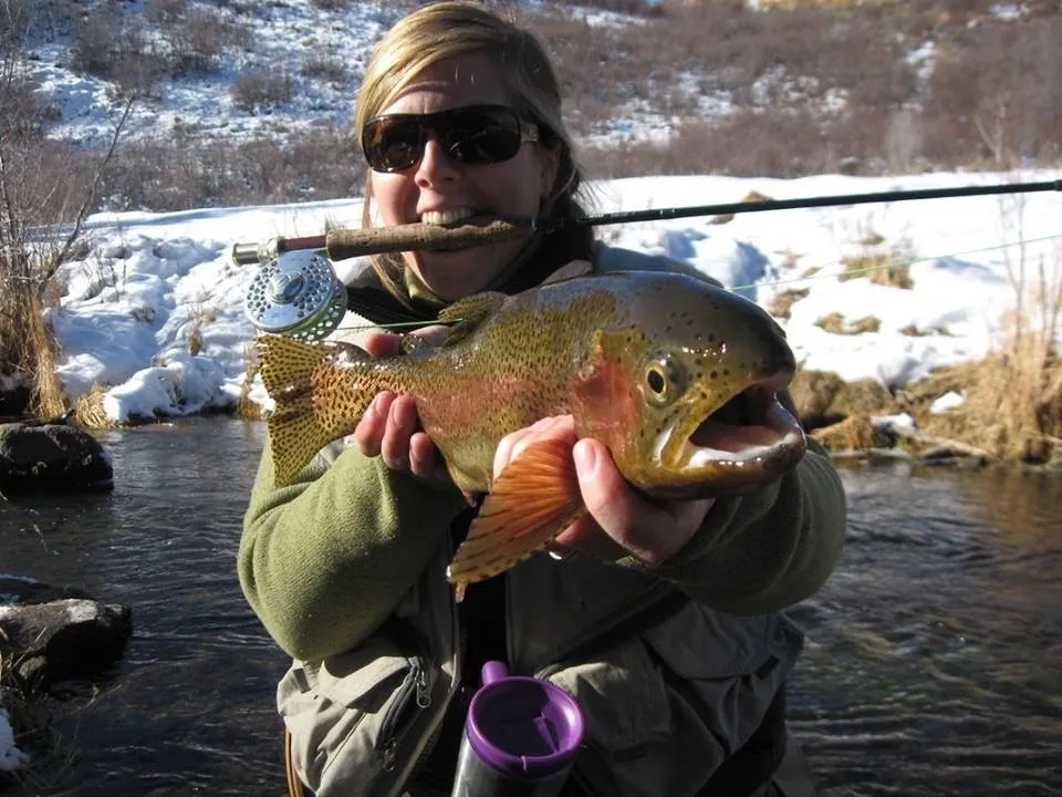 A woman holding a fish in her mouth.