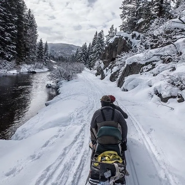 A person is riding down the snow covered road.